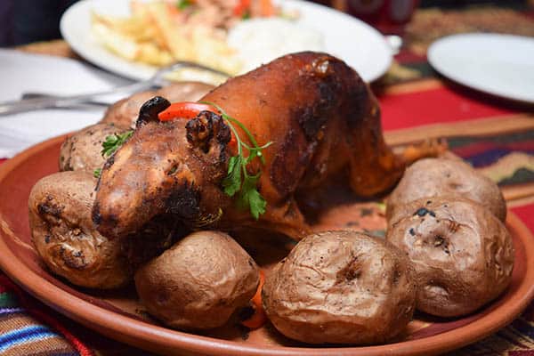 Roasted cuy on potatoes is a common sight in Peru