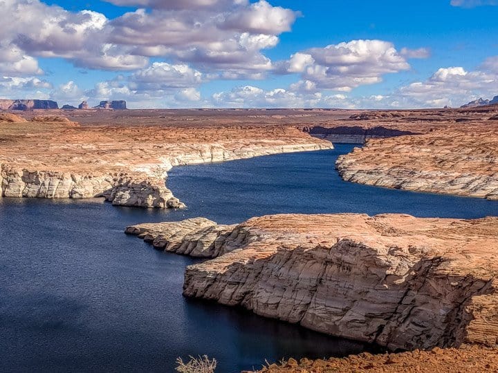 A beautiful natural contrast between the deep blue waters of Lake Powell and the red and white surrounding landscape