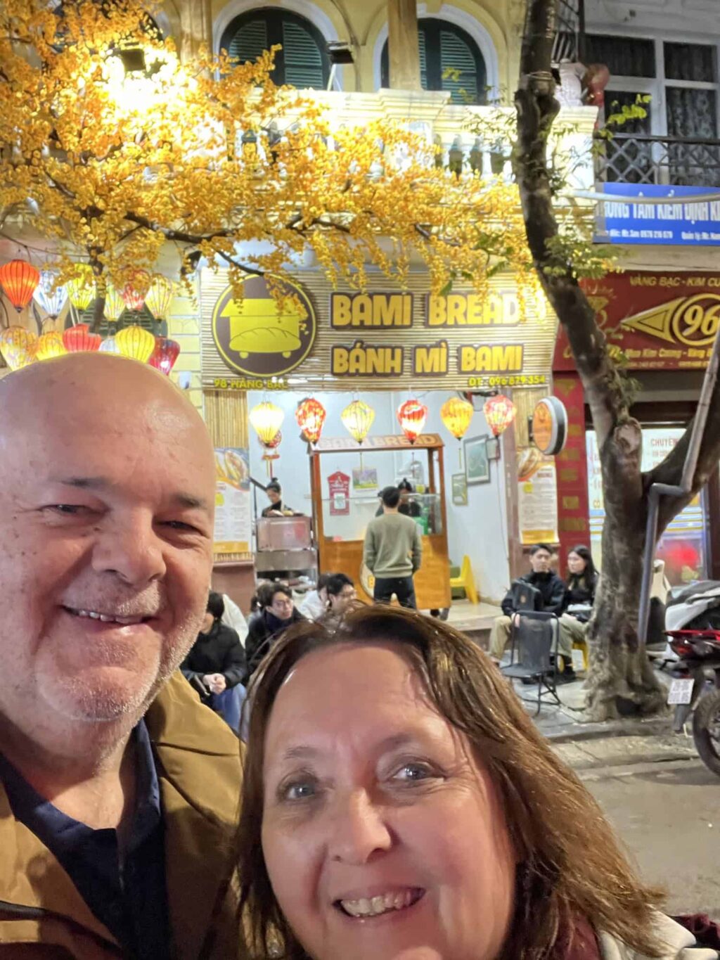 Dean and Pauline getting banh mi during a food tour in Hanoi