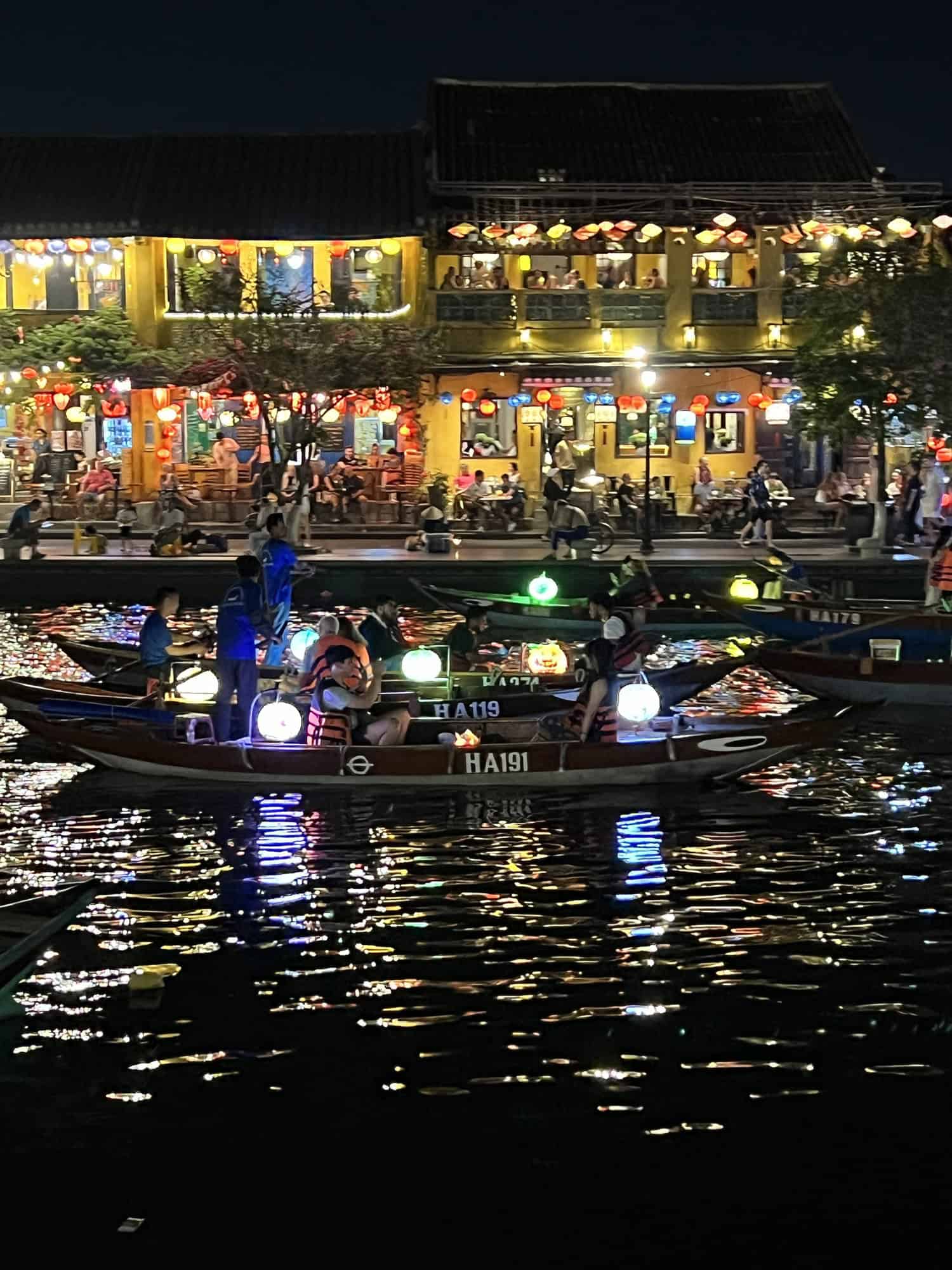 Boats on the river in old Hoi An, Vietnam with people releasing lanterns